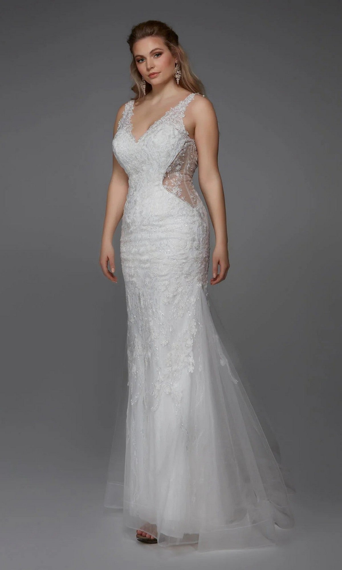 A woman poses against a gray background wearing the Alyce 7017 Long White Dress, a sleeveless, fitted gown featuring sheer side panels and a tulle trumpet skirt.